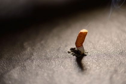 cigarette-butt-with-smoke-on-the-ground-PC7V7HW