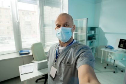 bald-mature-male-clinician-in-protective-mask-look-SLQEDU9