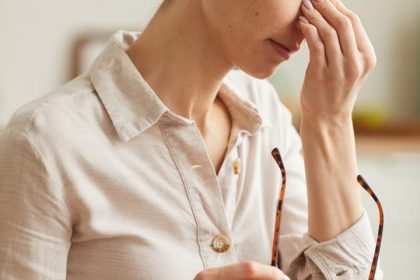 stressed-young-woman-taking-off-glasses-YMR9GKD