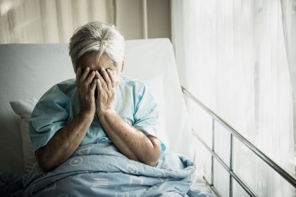 elderly-patients-sitting-in-bed-waiting-for-relati-K6CN8RS