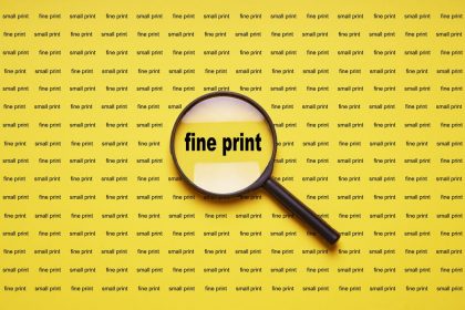 fine-print-enlarged-by-loupe-or-magnifying-glass-GXP9VL2